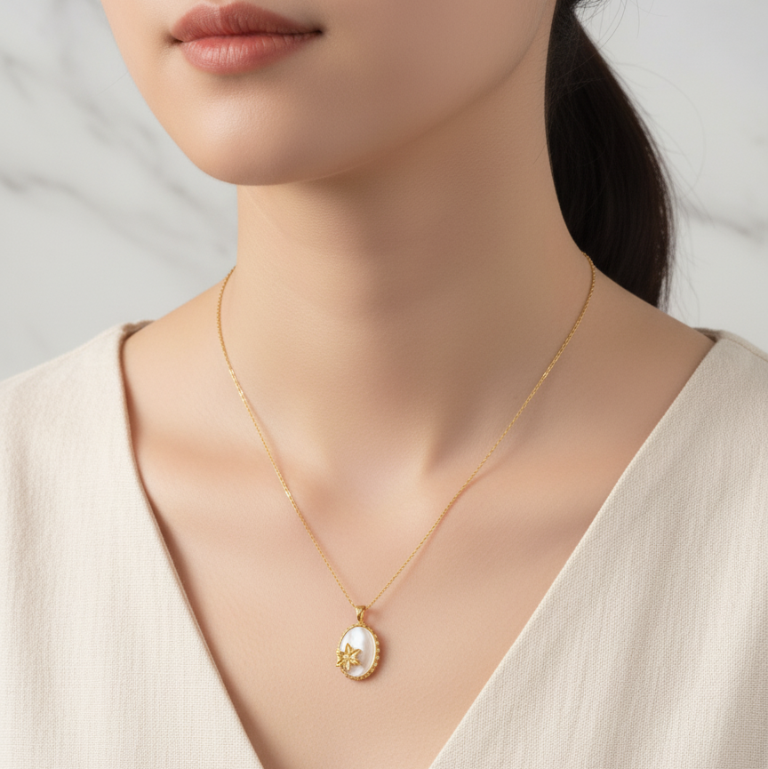 Woman wearing a gold necklace with a pendant against a neutral background