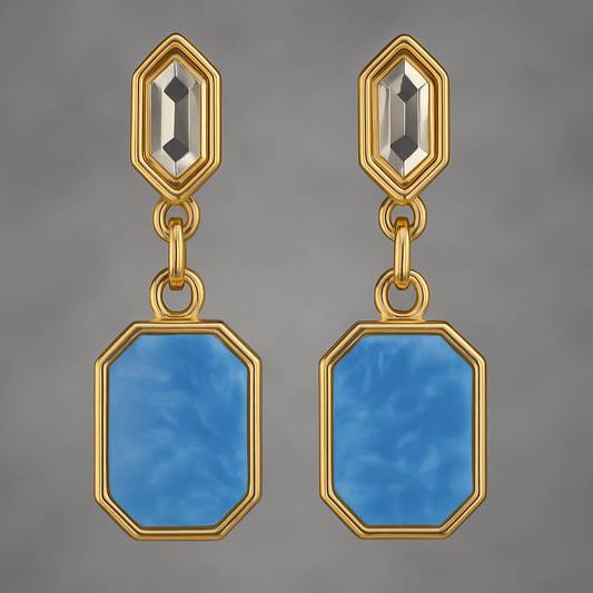 Gold earrings with blue stones on a gray background