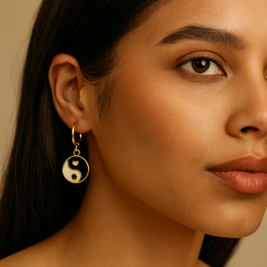 Close-up of a woman wearing a gold earring with a yin-yang symbol.