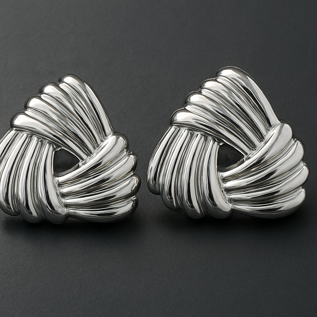 Pair of silver knot earrings on a dark gray background