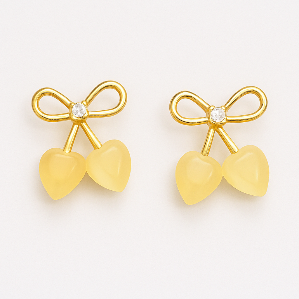 Gold-tone stud earrings featuring a bow design with a central crystal and two heart-shaped stone drops, resembling cherries.