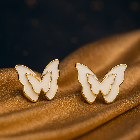 Butterfly-shaped earrings on a textured brown surface with a dark background