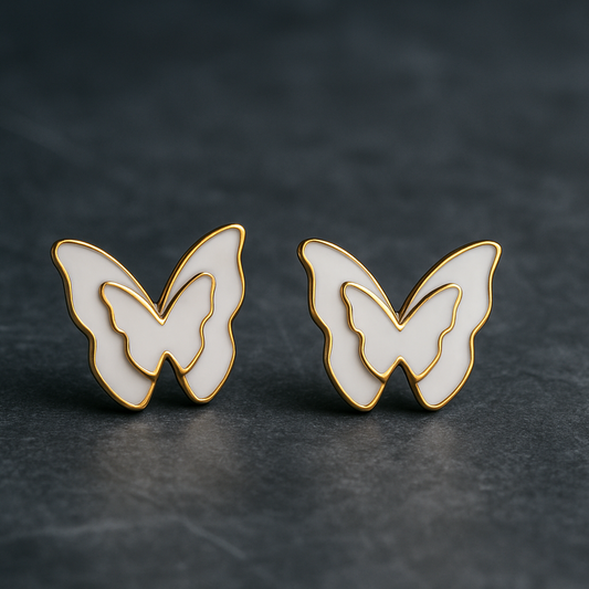 Butterfly-shaped earrings on a dark textured surface