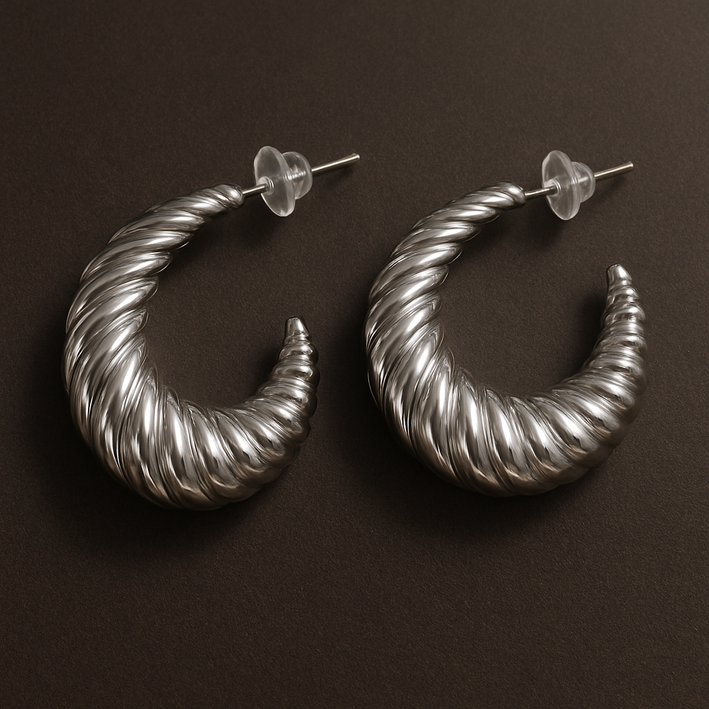 Pair of silver hoop earrings on a dark brown background