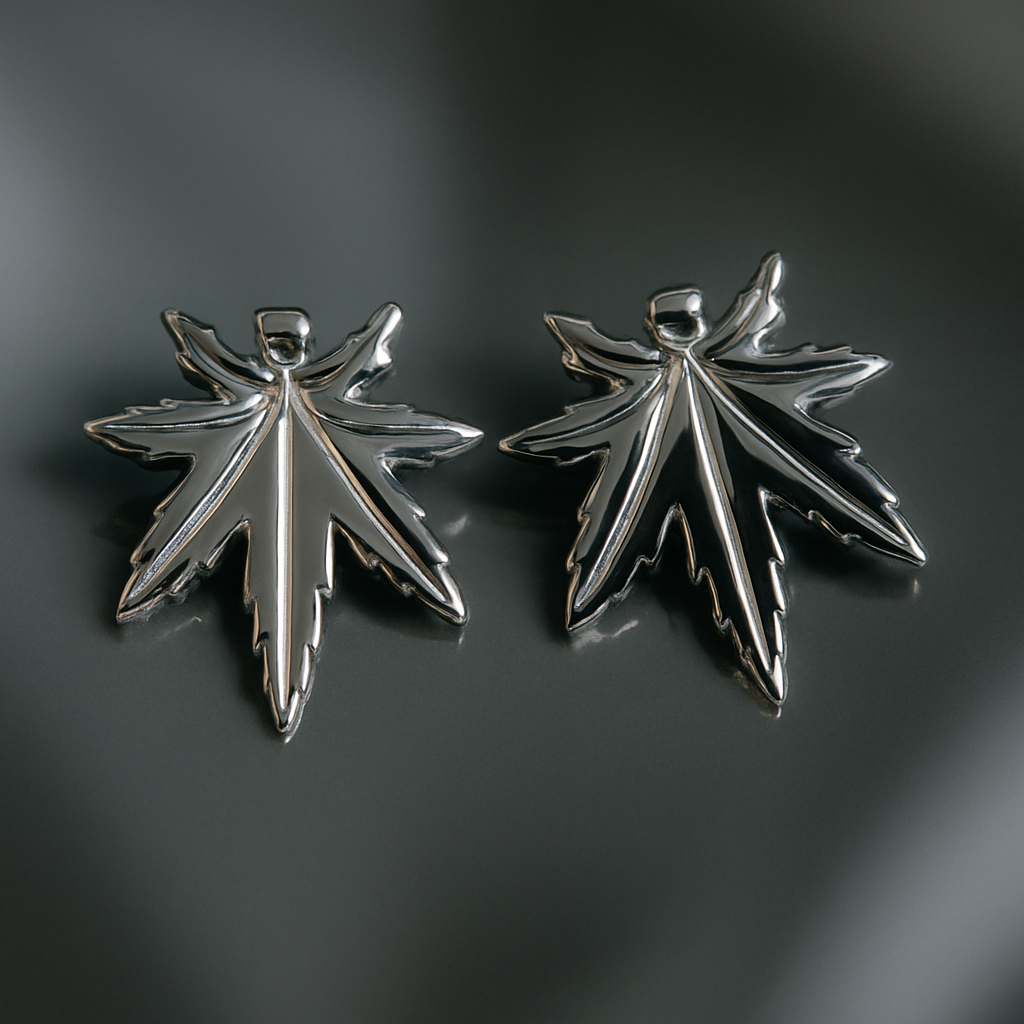Two silver leaf-shaped pendants on a dark gray background