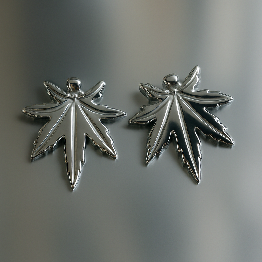 Two silver leaf-shaped pendants on a gray background