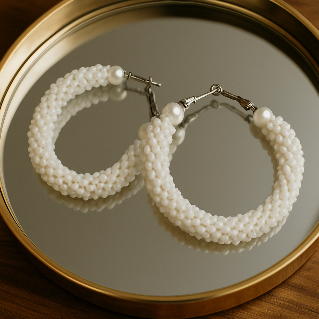 Pearl hoop earrings on a reflective surface