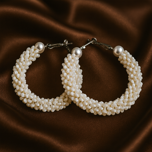 Pearl hoop earrings on a brown fabric background