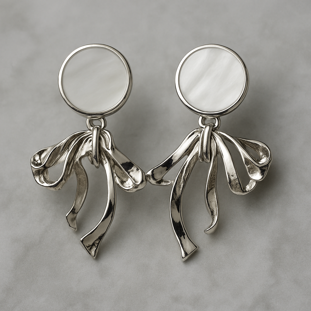 Elegant silver earrings with round mother-of-pearl studs and flowing ribbon-like drop design.