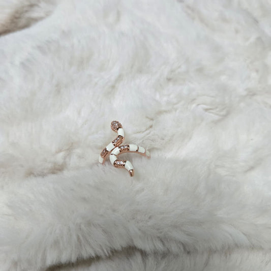 Rose gold and white beaded earring on a white fur background