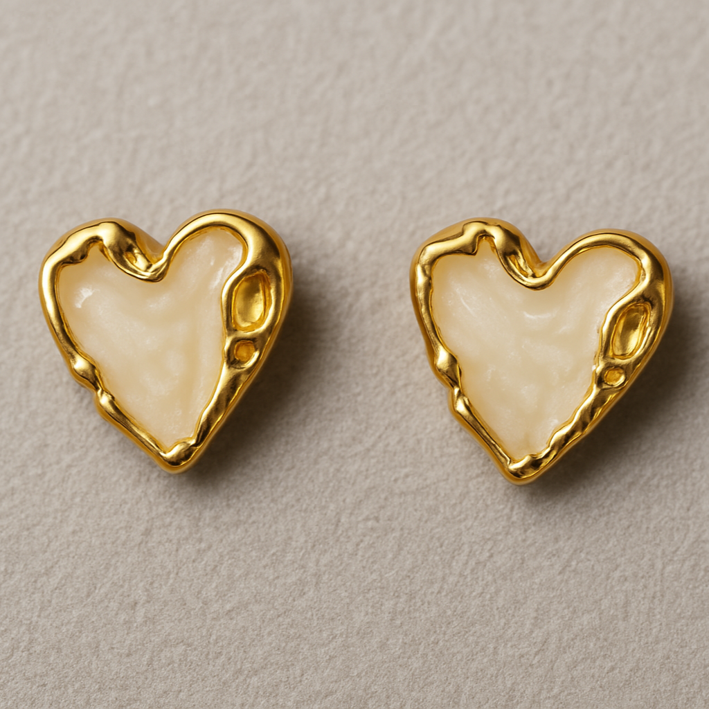 Pair of heart-shaped stud earrings with glossy Ivory enamel centers and textured gold-toned edges