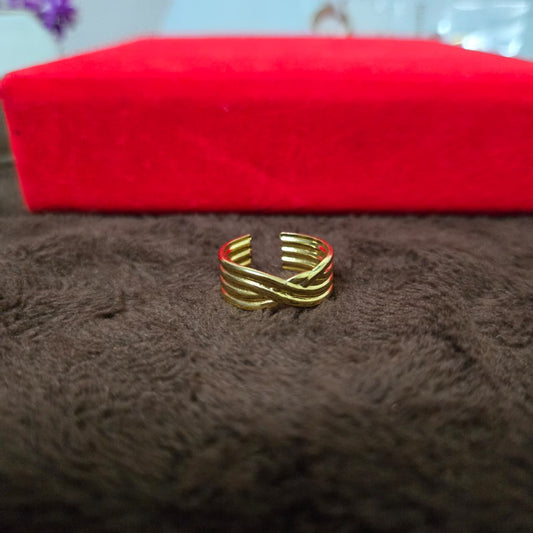 Gold ring on a brown textured surface with a red box in the background