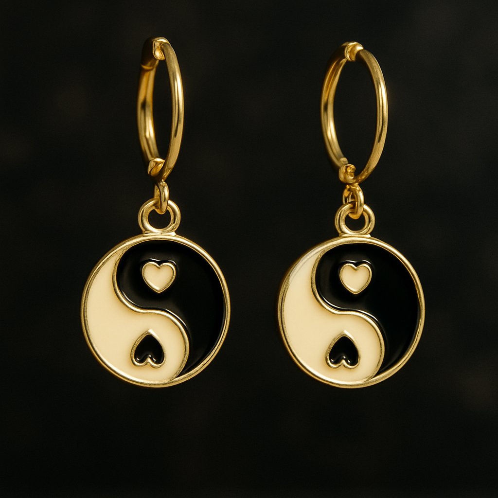 Gold earrings with yin yang design on a black background