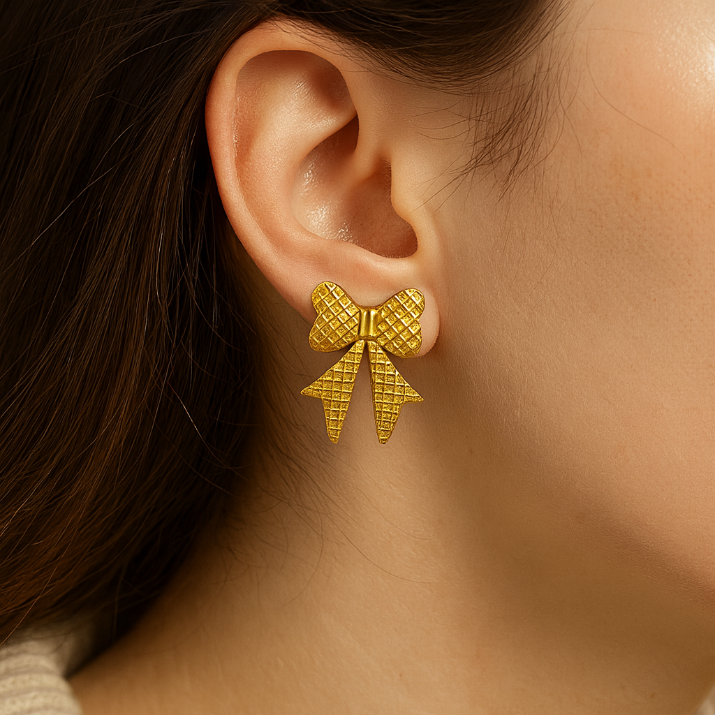 Gold bow-shaped earring worn by a person