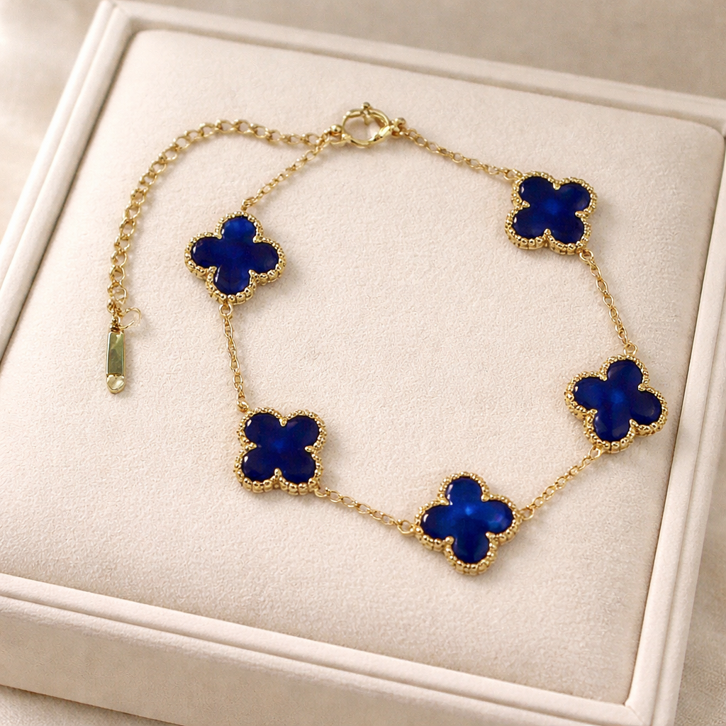 gold clover bracelet featuring deep royal blue clover charms framed in a delicate beaded border on a champagne box.