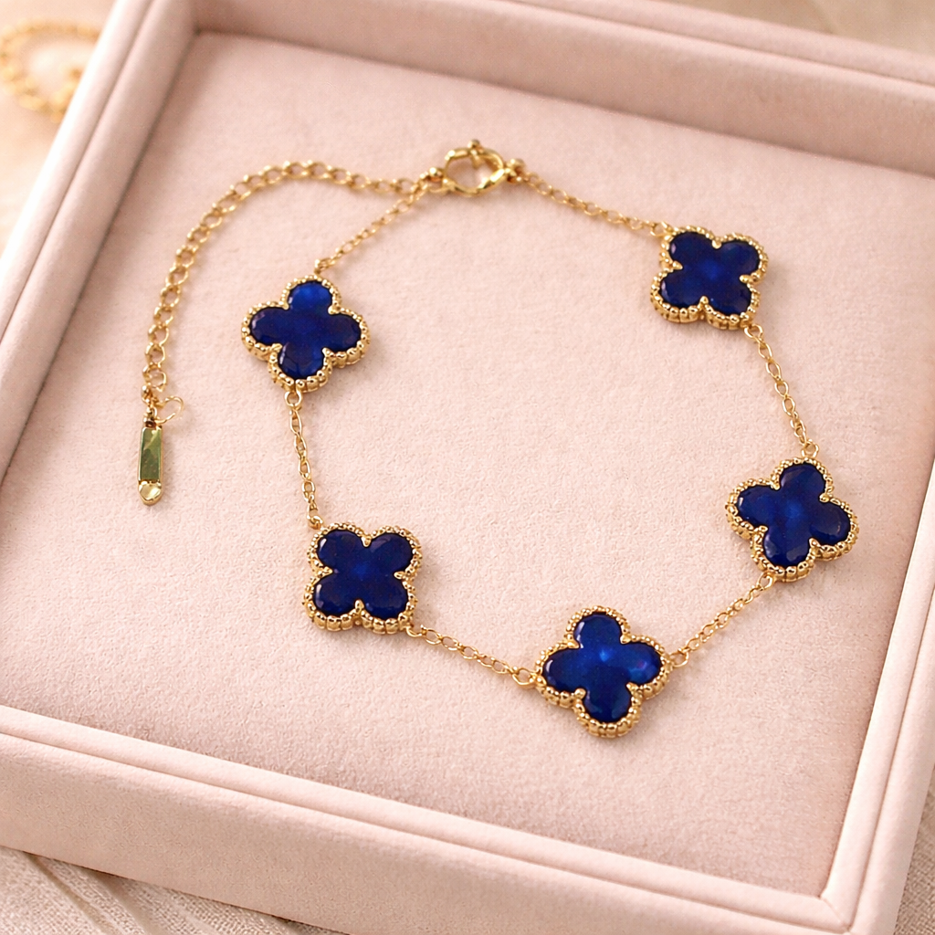 gold clover bracelet featuring deep royal blue clover charms framed in a delicate beaded border on a pink box.