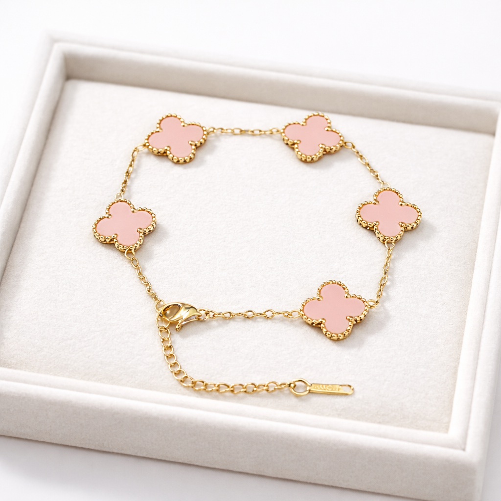 a bracelet with delicate pink clover-shaped charms framed in a radiant gold finish on a white box.