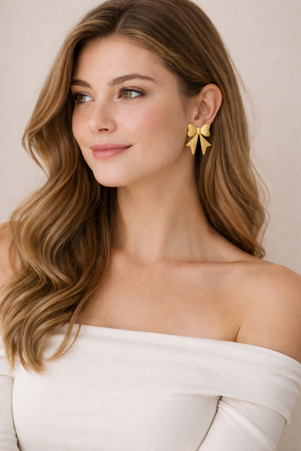 Gold bow-shaped earring worn by a person