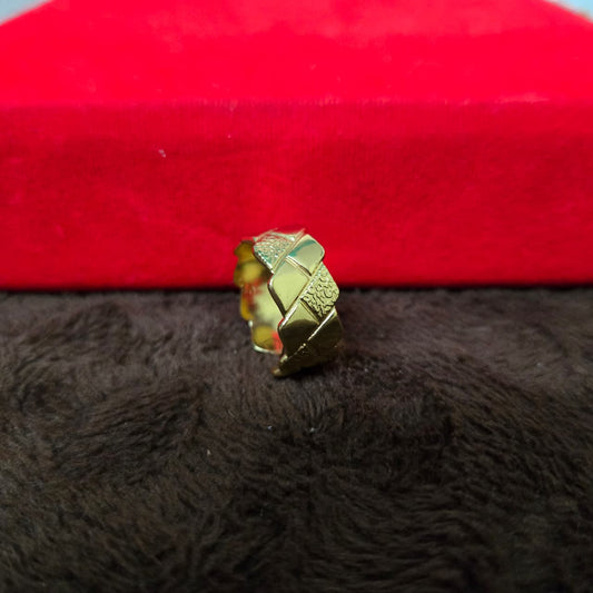 Gold decorative object on a red and black textured surface