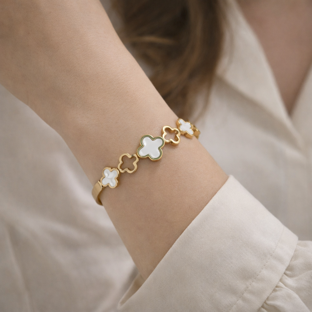 a woman wearing a bracelet with premium gold-tone finish with a blend of white mother-of-pearl and mint green enamel accents.