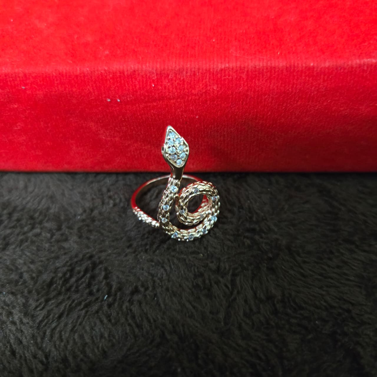 Silver ring with gemstones on a red and black textured surface