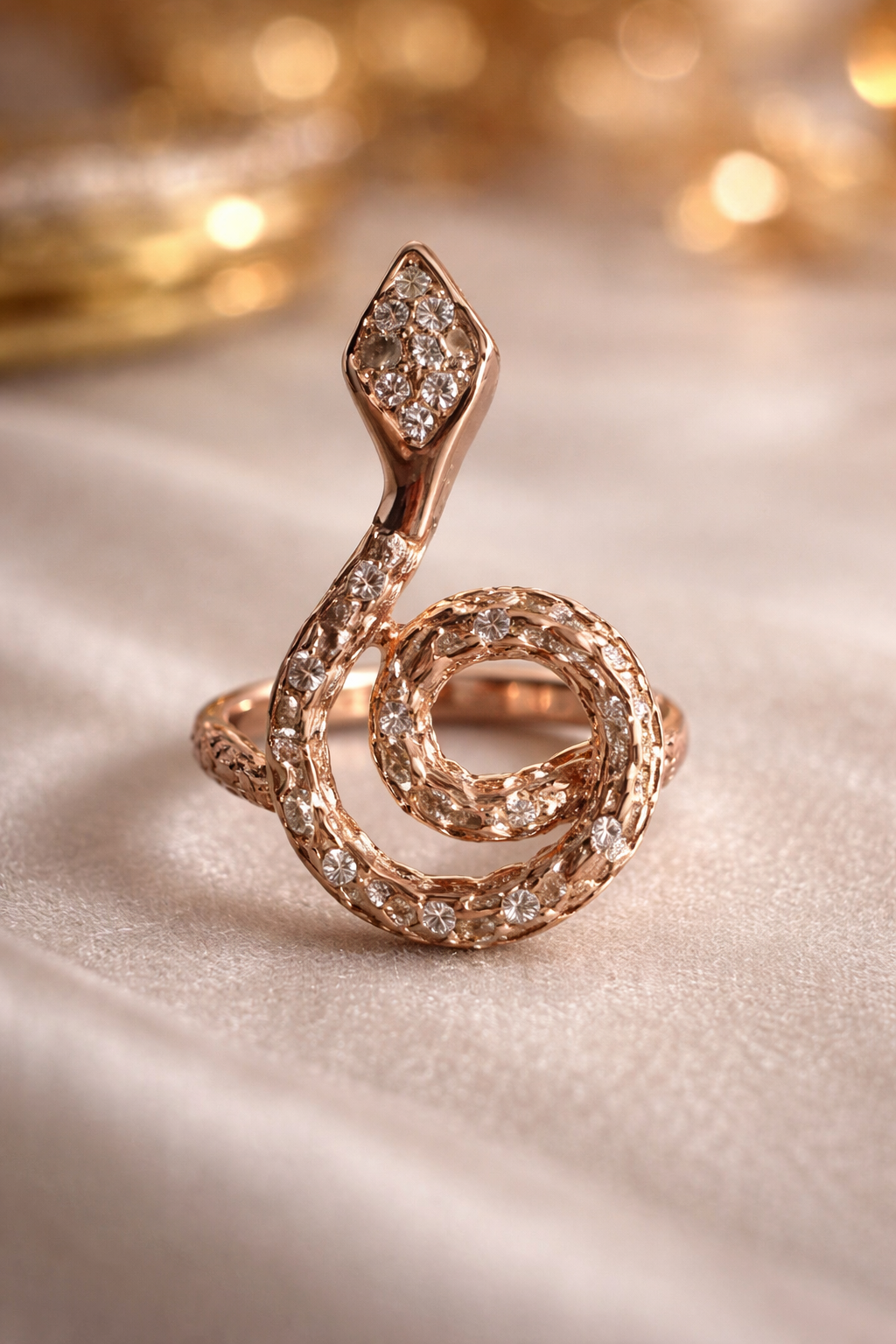 Rose gold spiral pendant on a light surface with blurred colorful background