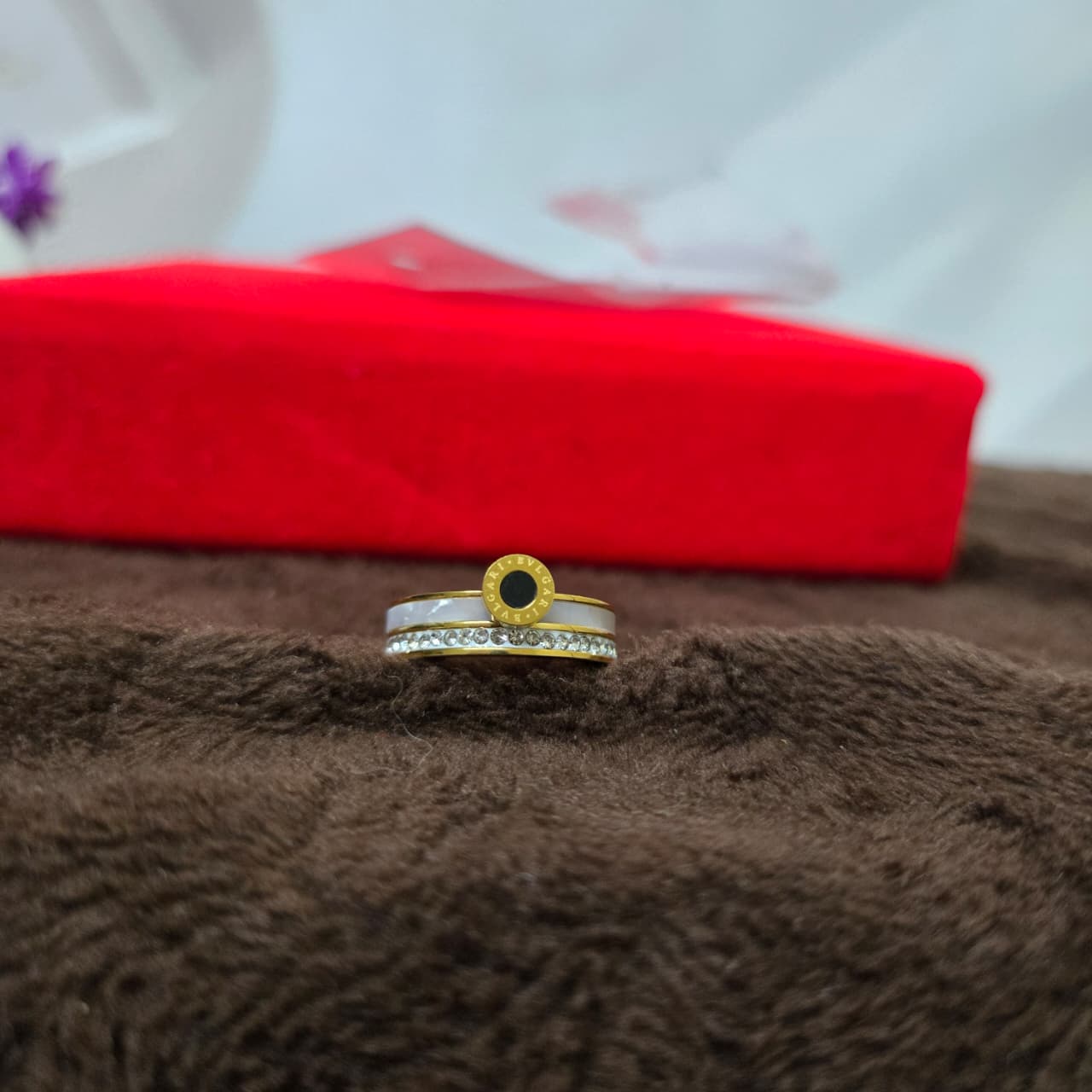 rings on a brown textured surface with a red fabric in the background