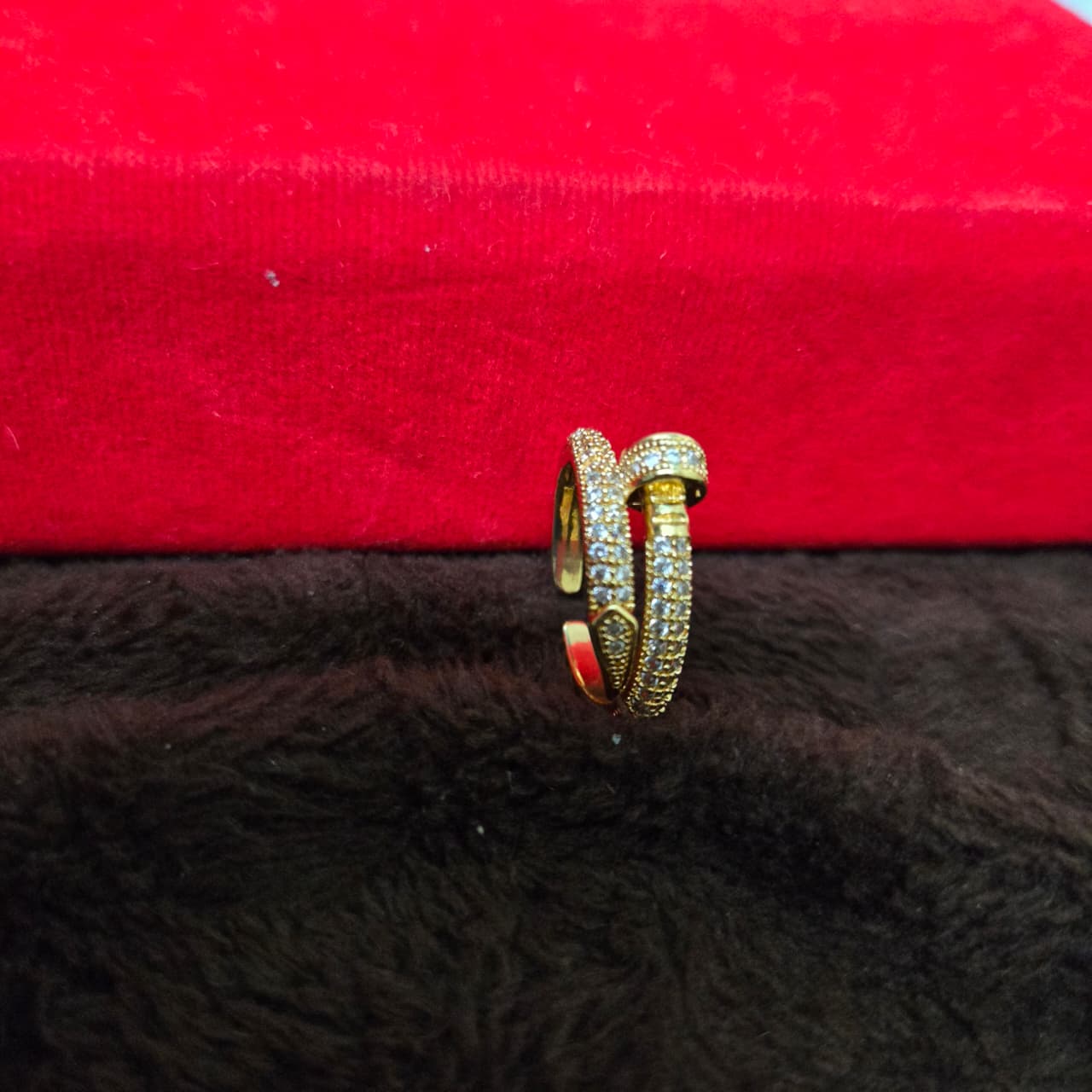 Gold ring with gemstones on a red and black textured surface