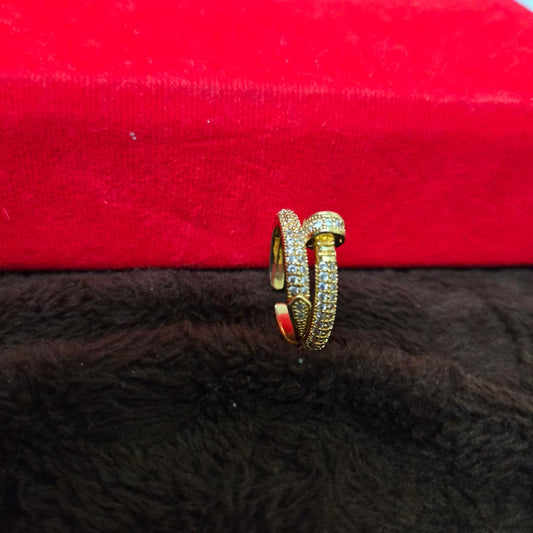 Gold ring with gemstones on a red and black textured surface