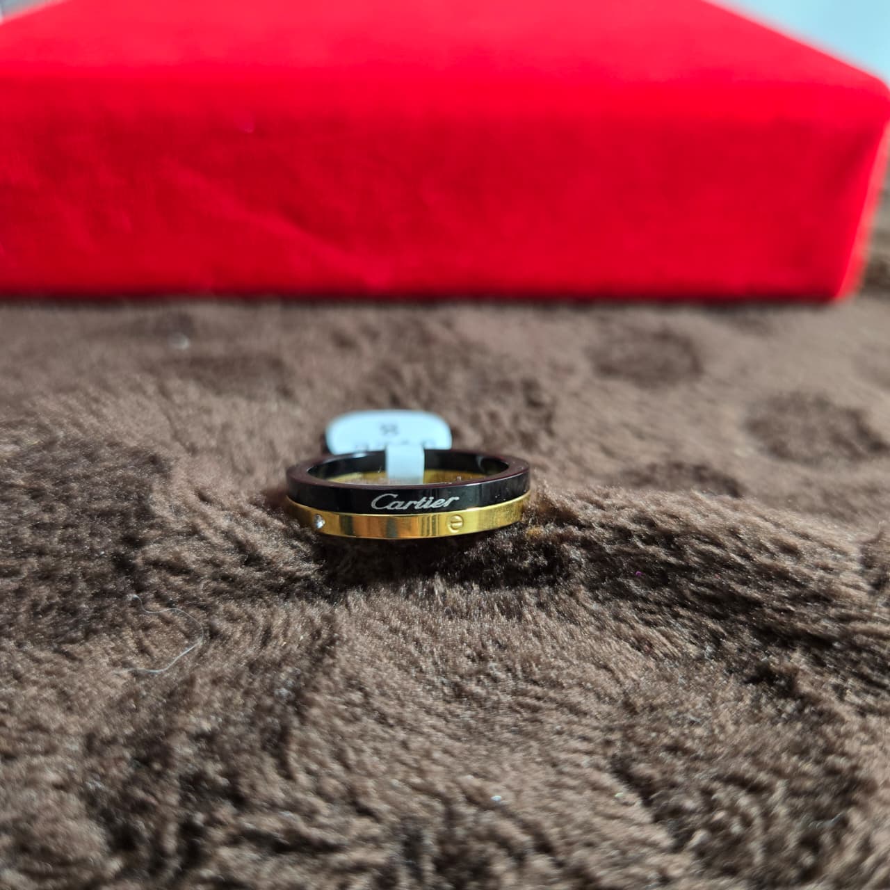 Cartier ring on a textured surface with a red box in the background
