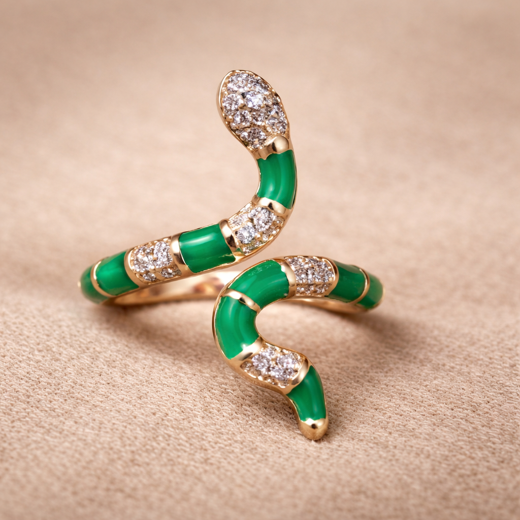 Rose gold and green snake-shaped brooch on a pink background.