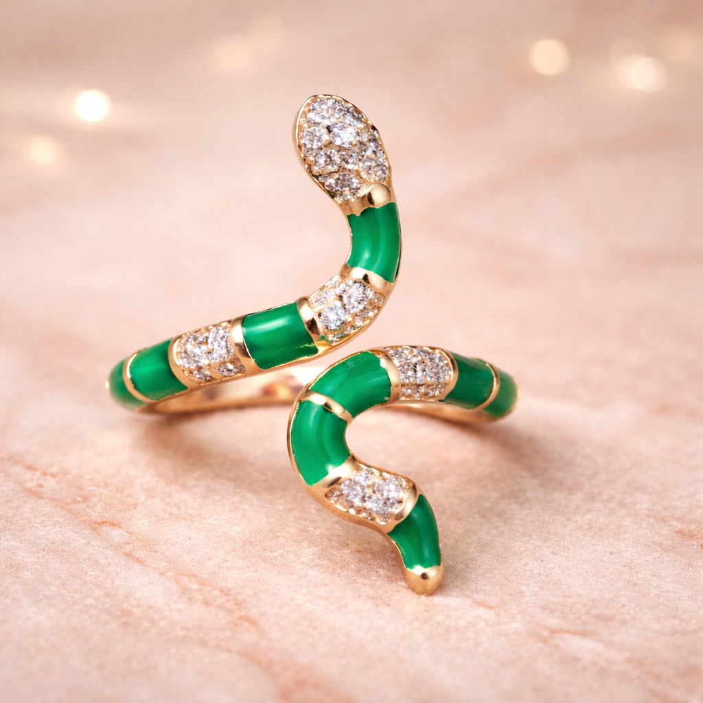 Rose gold and green snake-shaped brooch on a pink background.