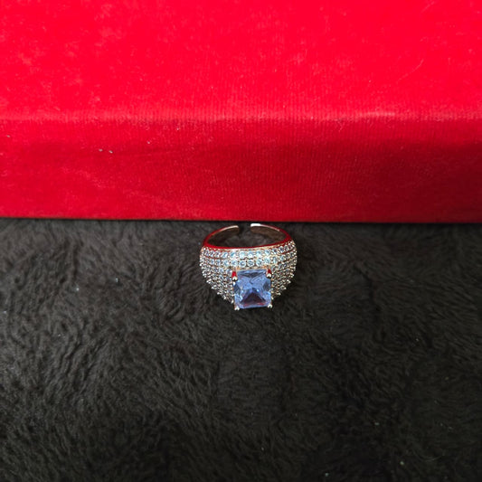 Ring with a prominent gemstone on a red and black textured surface