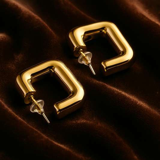 Gold hoop earrings on a brown velvet background