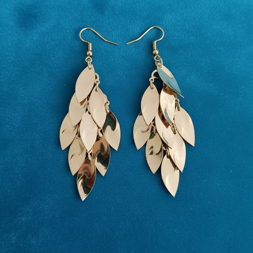 Gold leaf-shaped earrings on a blue background