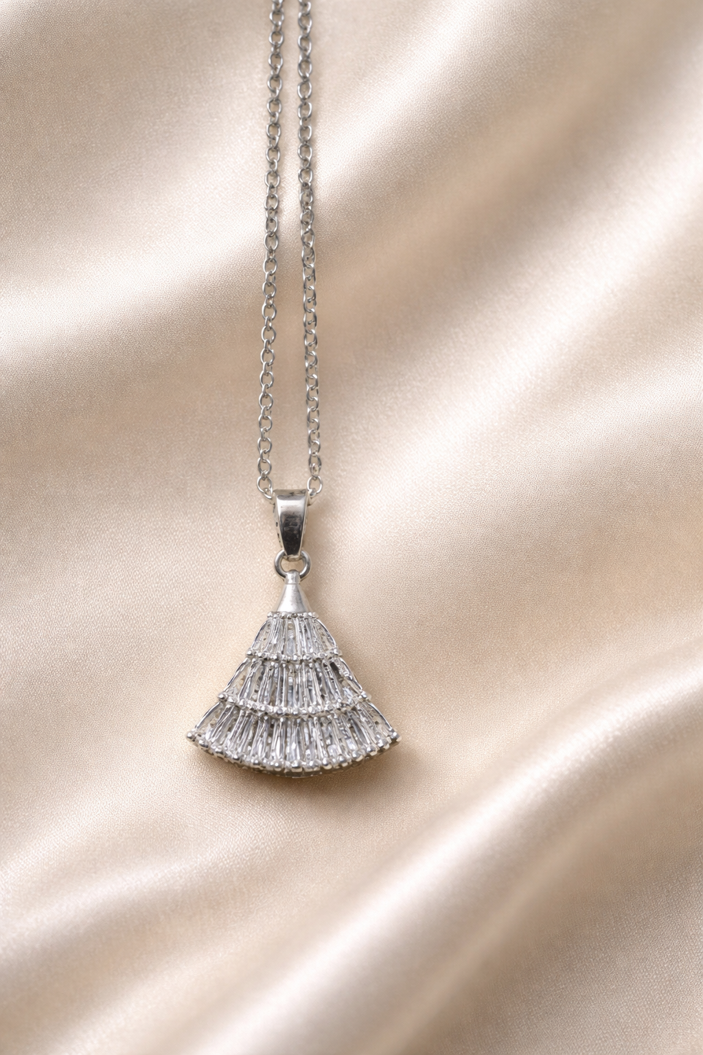 The pendant on a champagne cloth background.