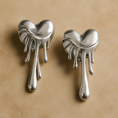Pair of silver heart-shaped earrings on a beige background