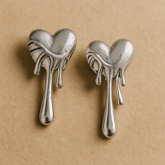 Pair of silver heart-shaped earrings on a beige background