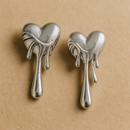 Pair of silver heart-shaped earrings on a beige background