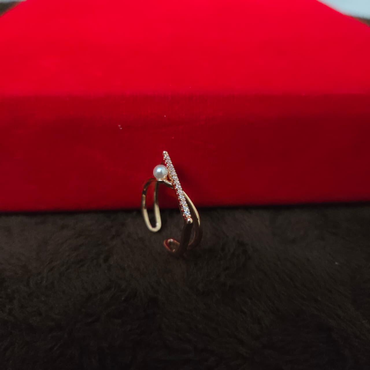 Jewelry box with a ring on a red and black textured surface