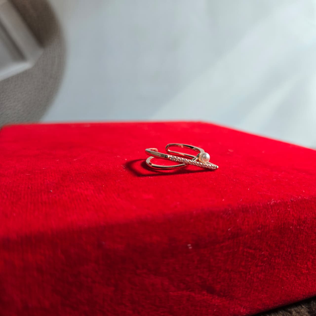 Gold ring on a red cushion with a blurred background
