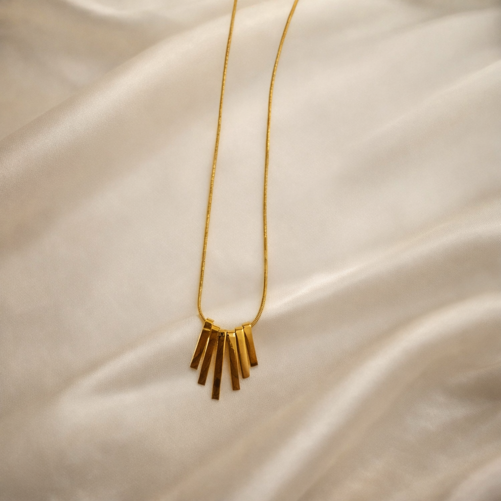 the golden pendant on a white cloth background.