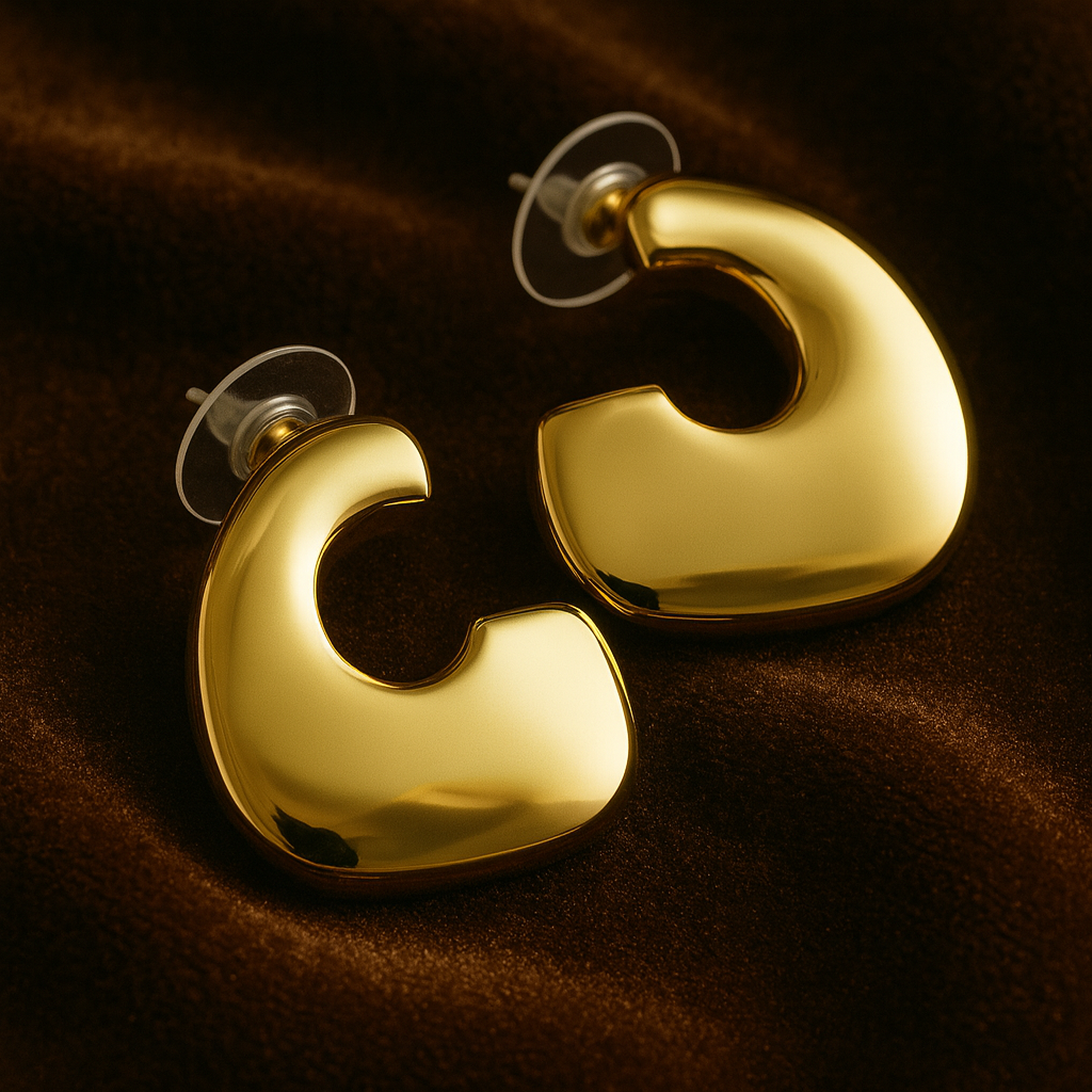 Gold hoop earrings on a brown fabric background