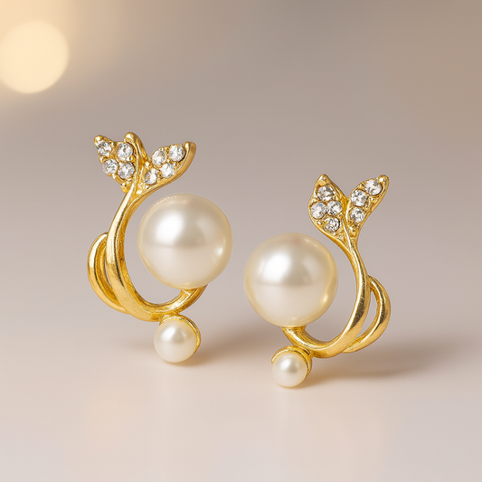 Gold earrings with pearls and crystals on a beige background
