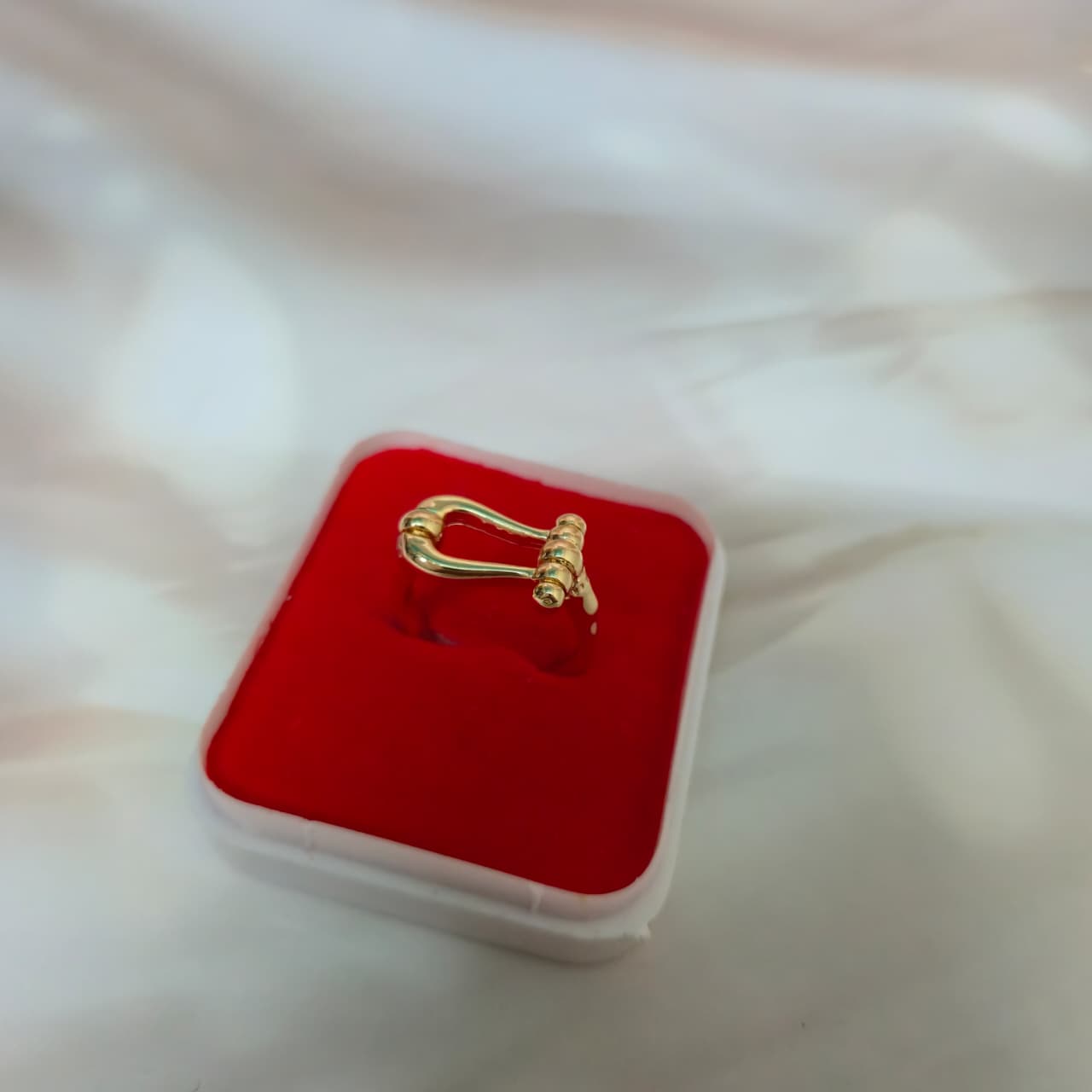 Adjustable gold-finish wrap ring with anti-tarnish coating displayed in a red jewelry box