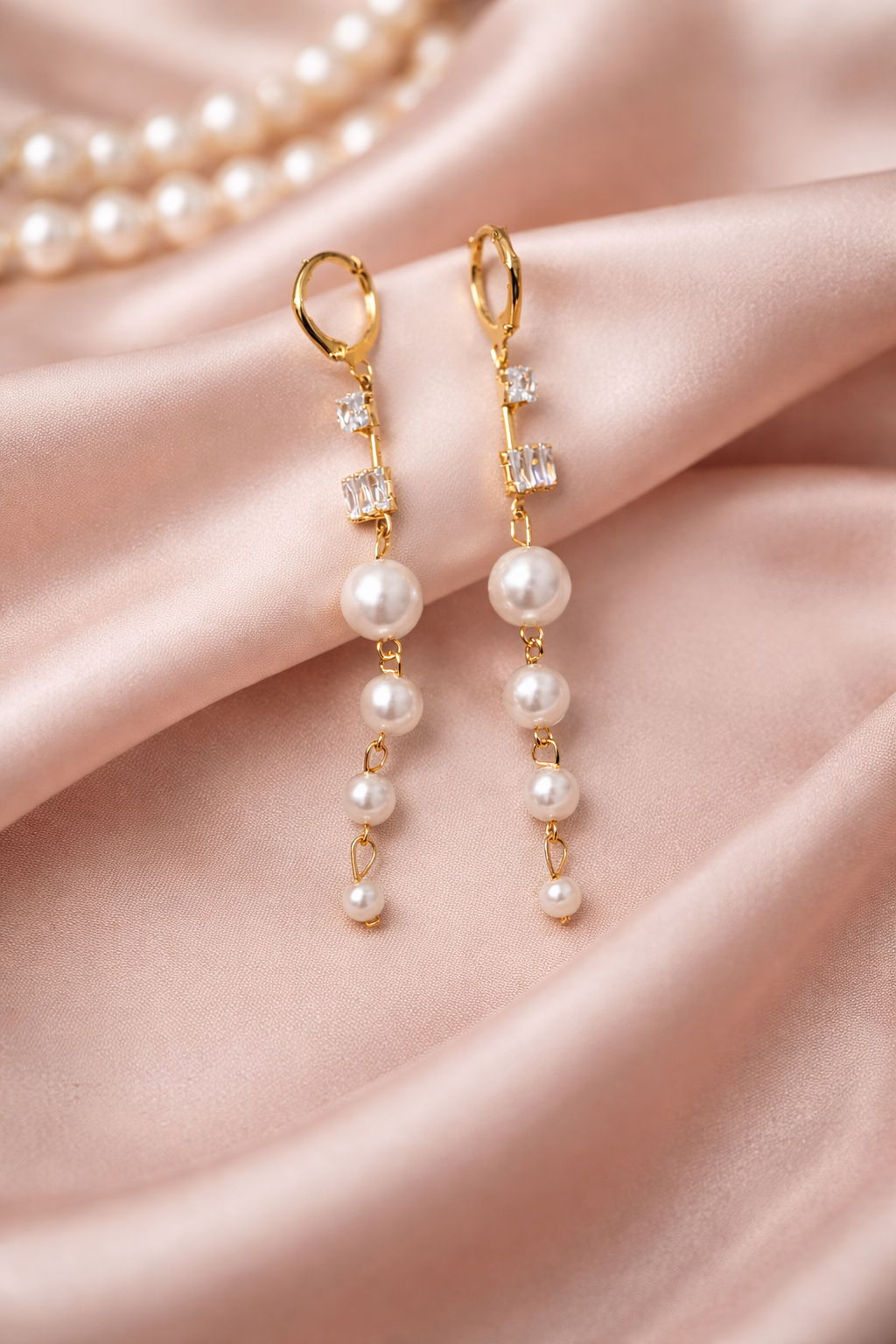 The earings on a pink cloth background 