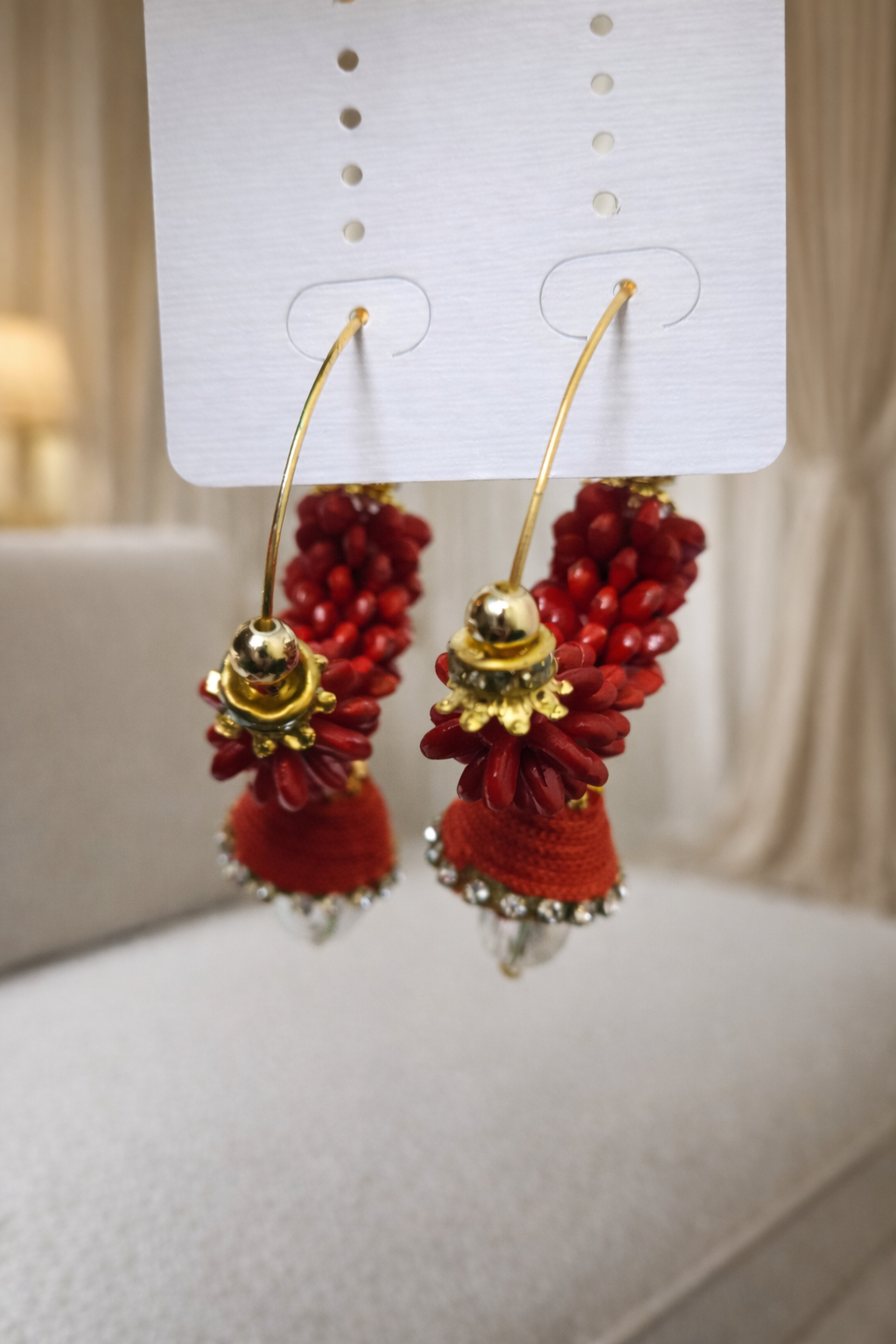 The earrings dangling from the cardboard on a couch background 