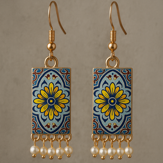 Pair of earrings with floral design and pearl accents on a brown background