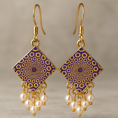 A pair of handcrafted square-shaped dangle earrings featuring intricate purple and gold mandala designs, accented with clusters of small white faux pearls