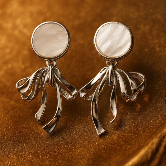 Elegant silver earrings with round mother-of-pearl studs and flowing ribbon-like drop design.